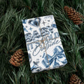 Gift wrapped in Baby It's Cold Y2K Christmas paper with chrome lettering, icy blue bows and hearts, tied with twine on pine branches