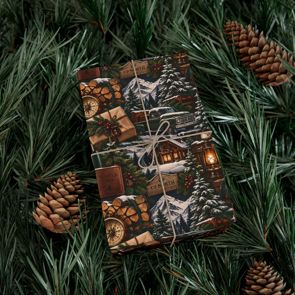Cabin Season Christmas wrapping paper on a twine-tied gift, featuring a rustic mountain lodge and snowy winter landscape