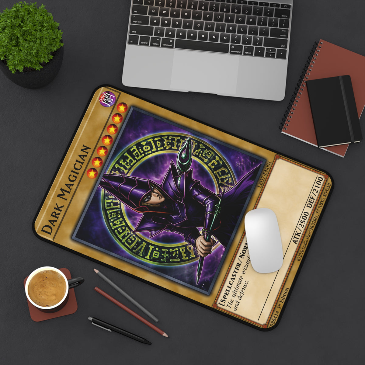 Dark Magician-inspired trading card desk mat on a gaming desk beside a laptop, coffee cup and pencils